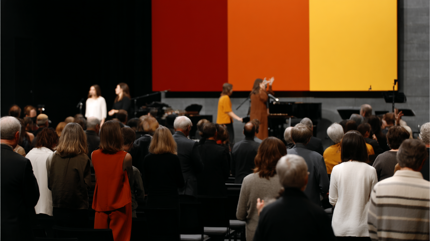 People worshipping in a modern church setting, with a colorful backdrop and musicians performing, reflecting community support and engagement in faith.