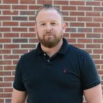 Man standing outdoors against brick wall