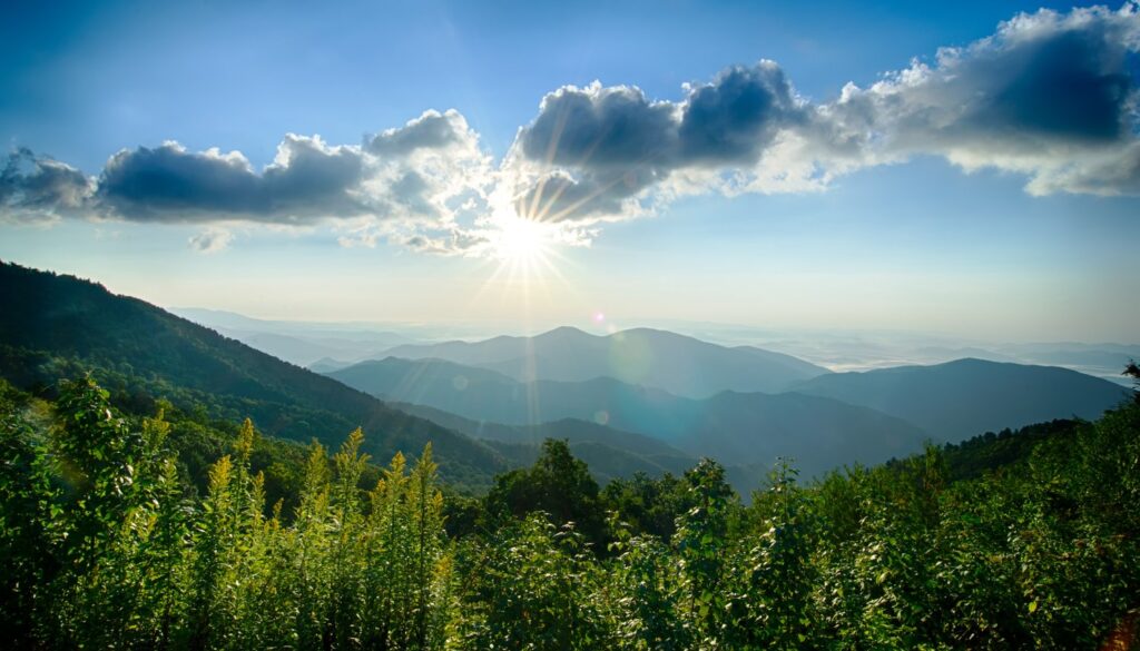Sunlight breaking through clouds over mountains