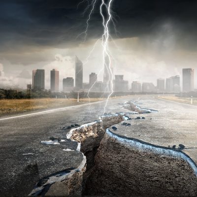 City skyline with cracked road and lightning, representing conflict and disaster management in church settings.