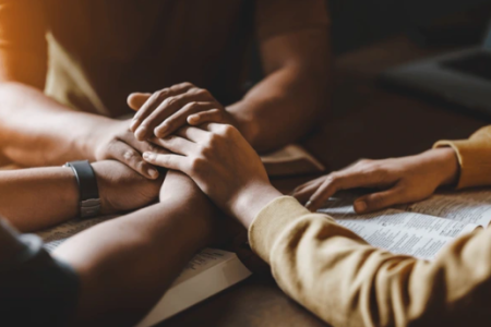 Close-up of hands clasped together in prayer
