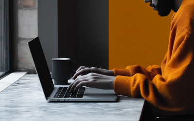 Person typing on a laptop with a coffee cup, symbolizing engagement in prayer initiatives and community connection for Multiply the Church.