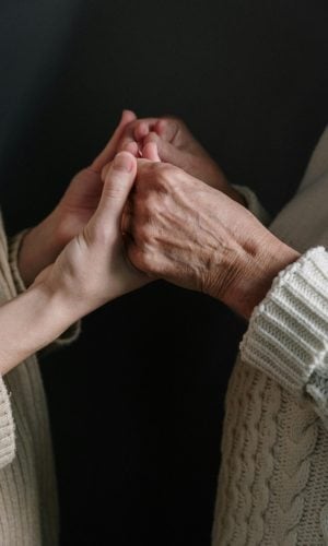Hands of different ages holding each other, symbolizing connection and community support in faith-based initiatives.